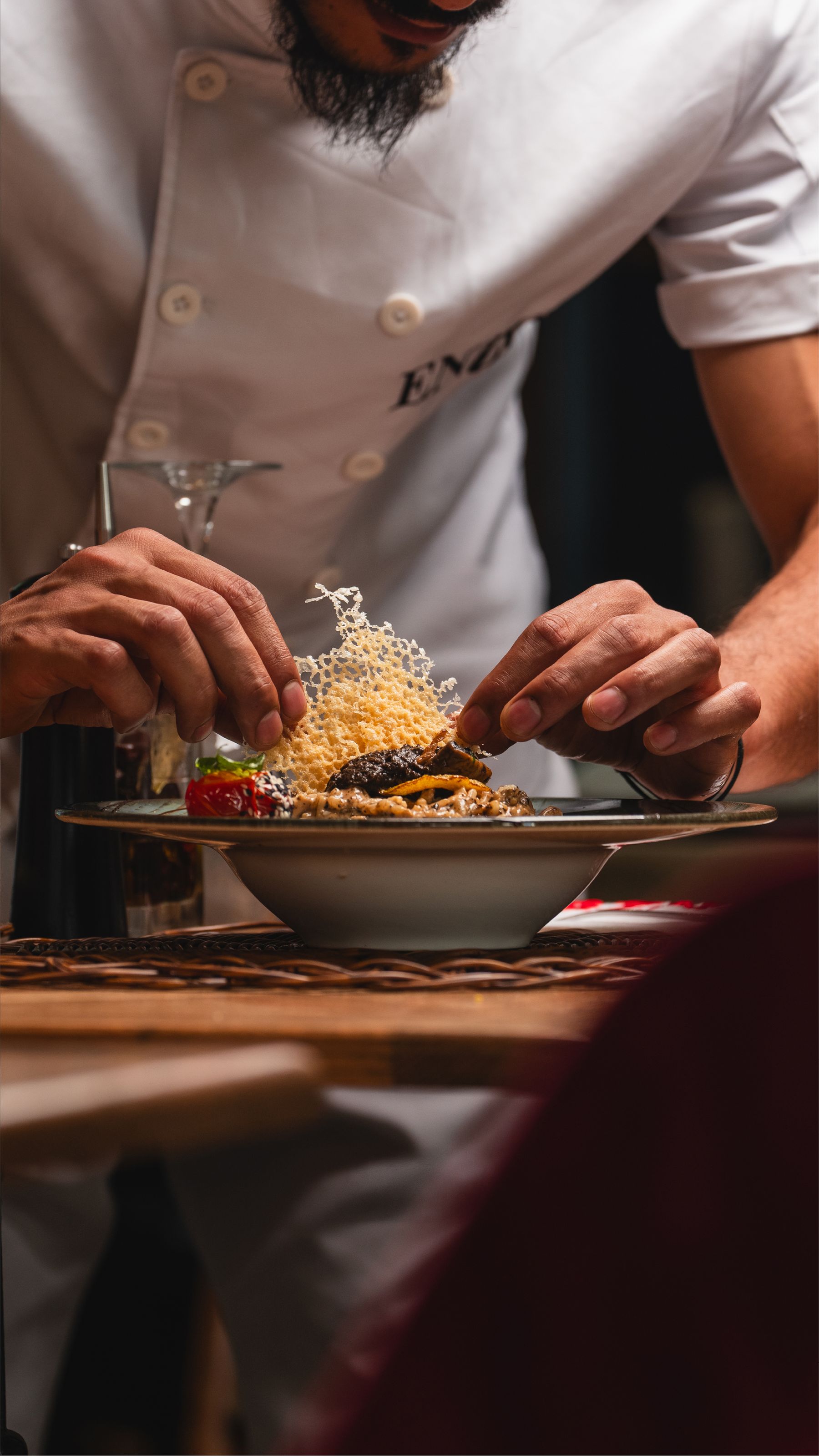 Chef al lavoro su un impiattamento curato, foto d’ambiente